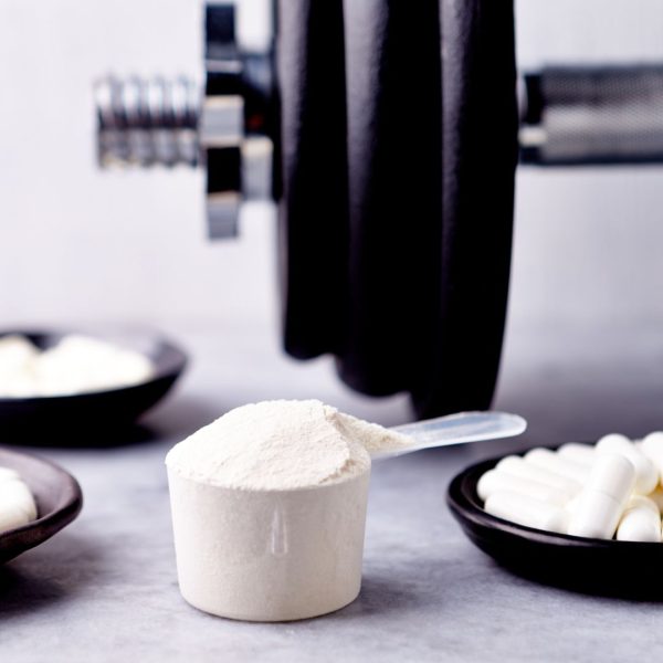 different forms of creatine in front of a barbell